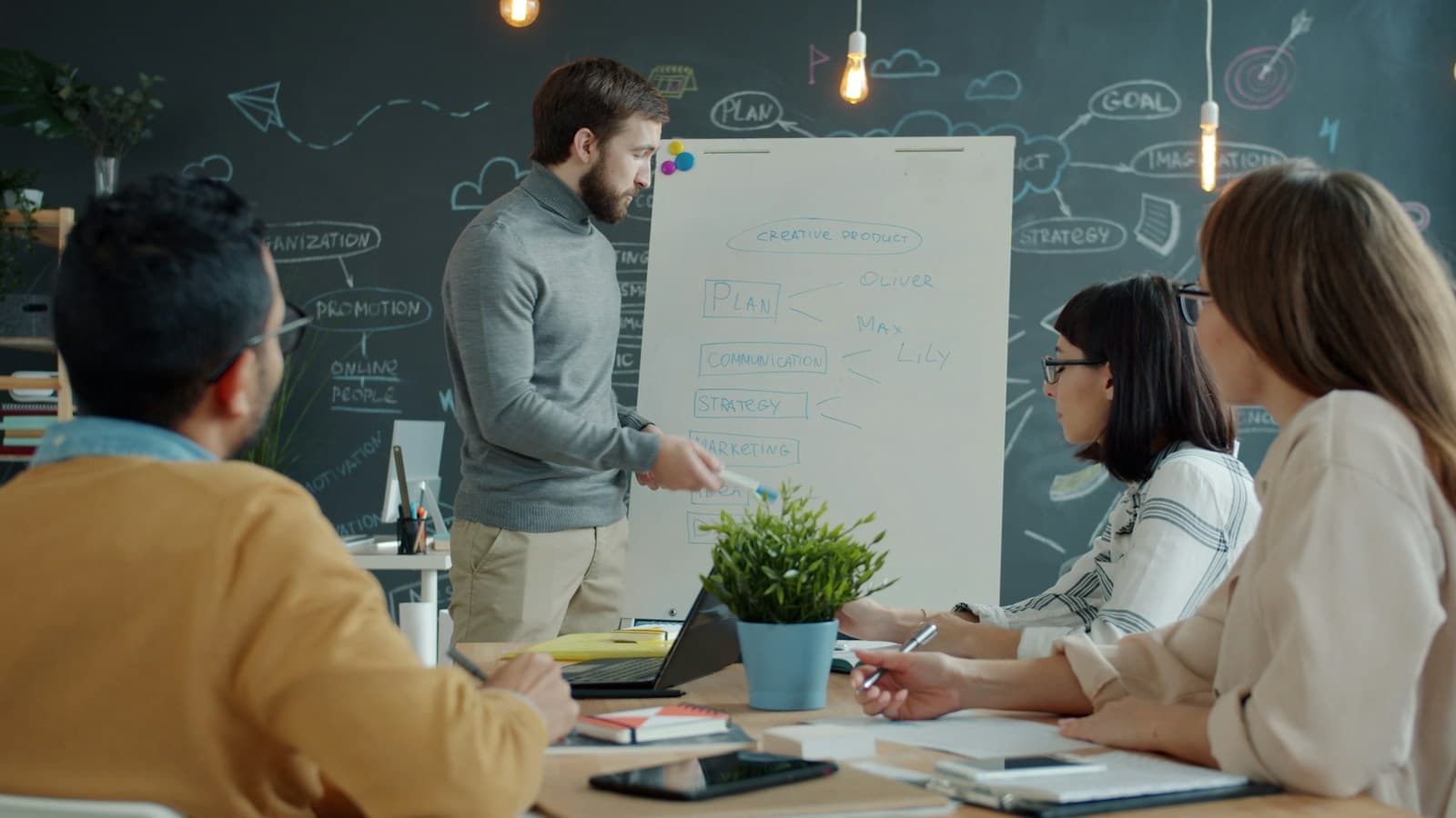 A strategy workshop with a team gathered around a whiteboard