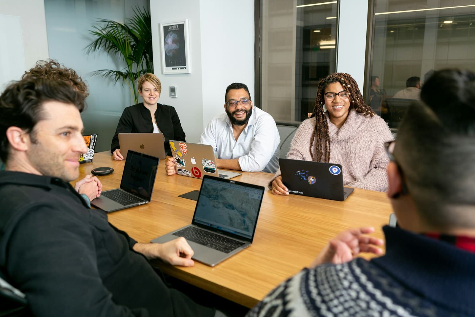 A product team with laptops listening to a colleague in a planning meeting