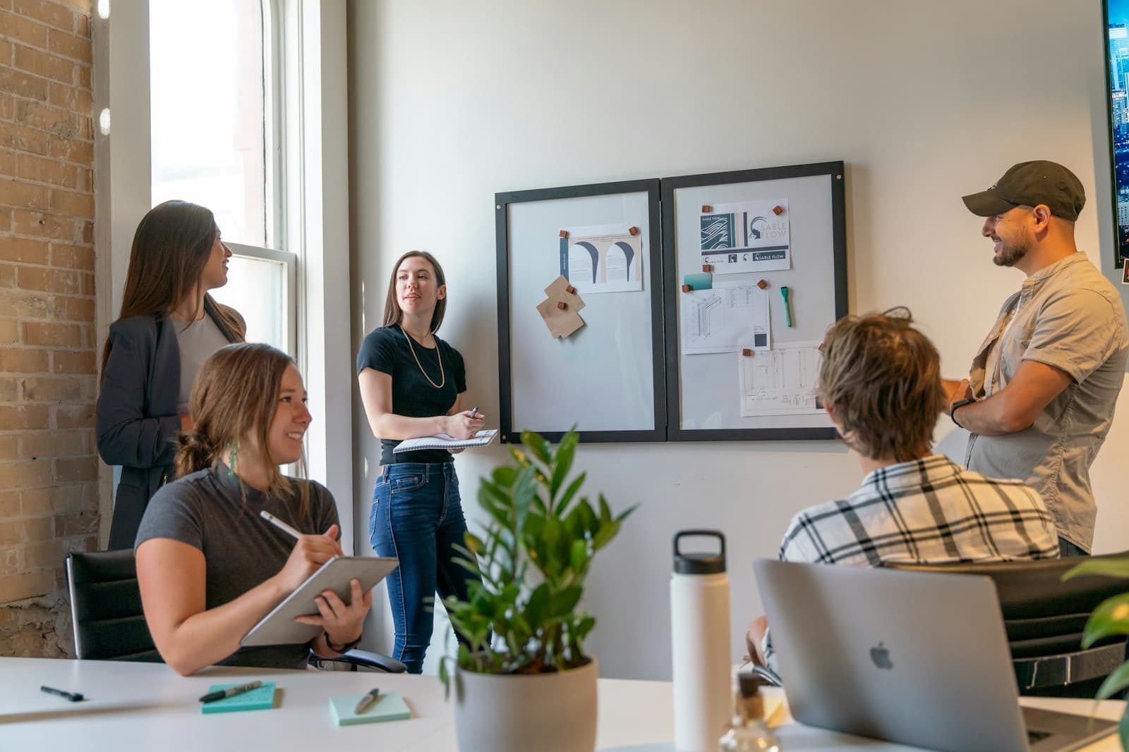 A team collaborating around a whiteboard in a sunlit office