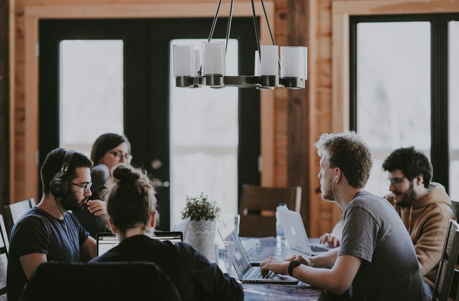 A development team working together at a long table with laptops