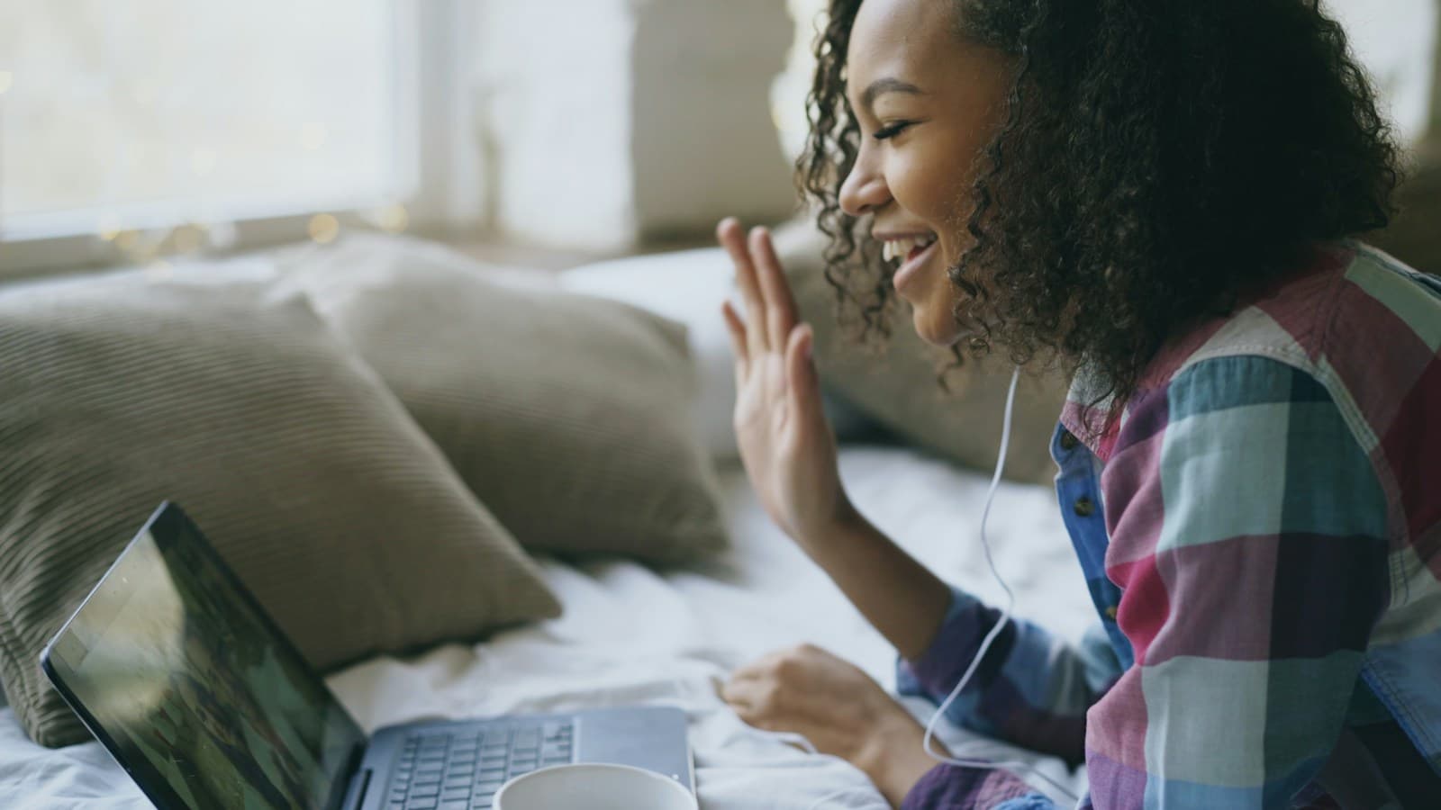 A colleague waving on a video call while working from home