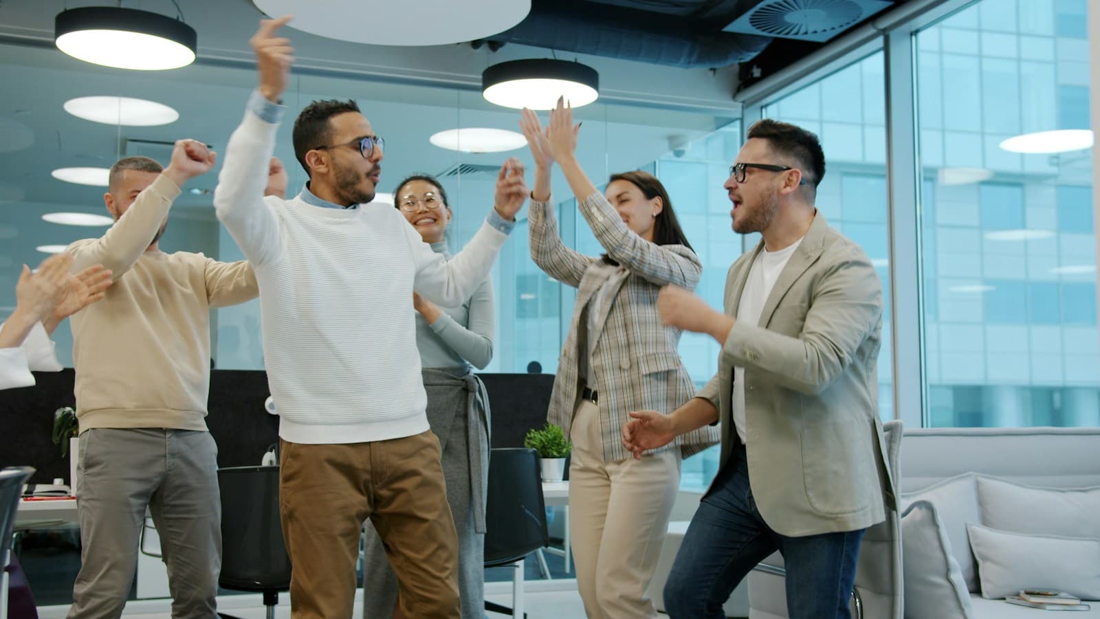 Colleagues celebrating together in a bright office