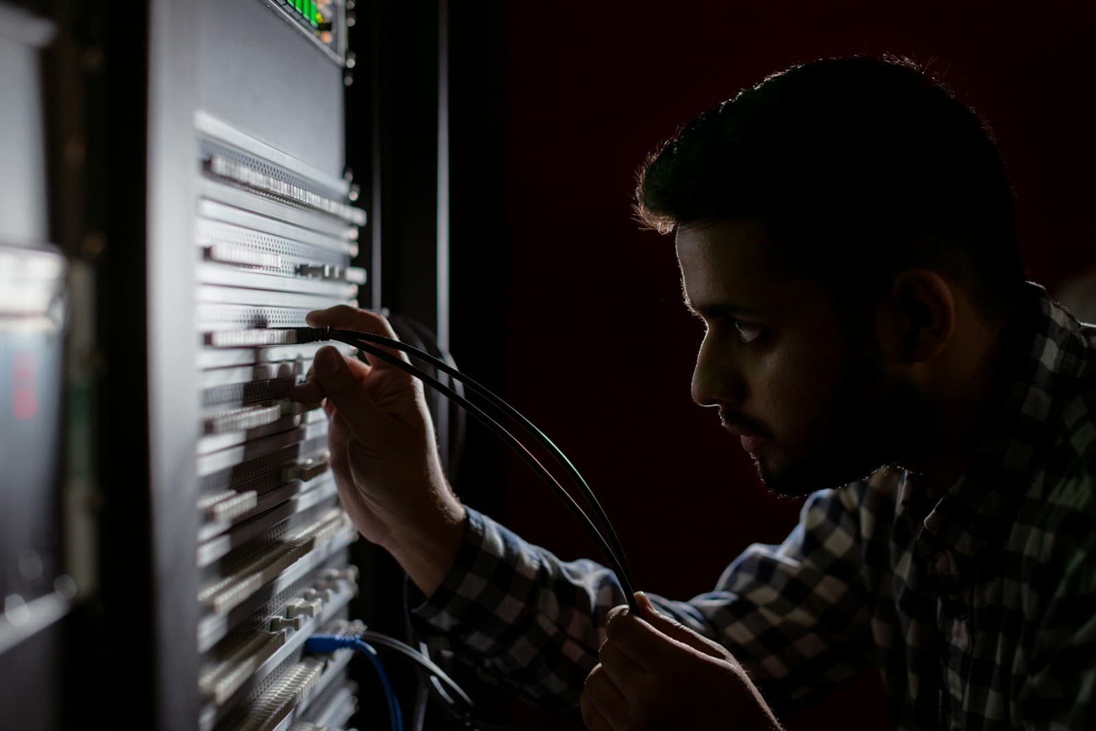 An engineer connecting network cables in a server rack
