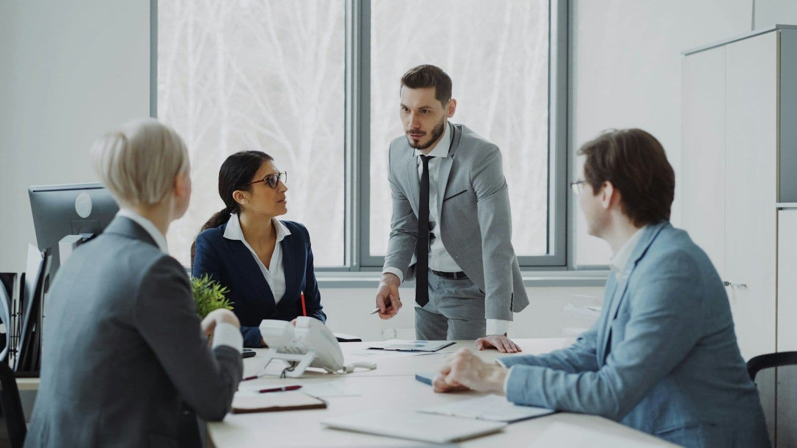 Four business professionals in discussion around a meeting table