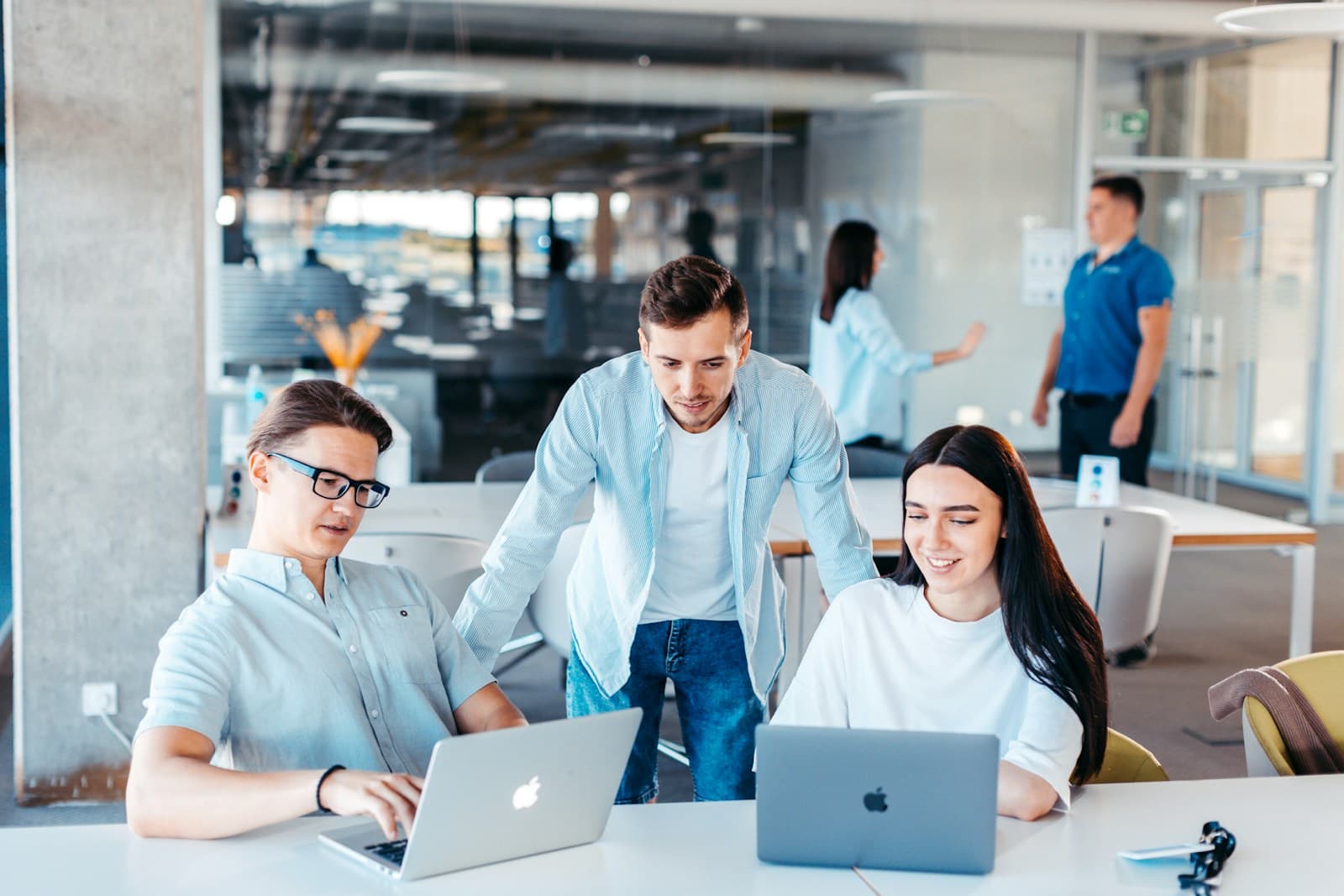 Colleagues working together on laptops in a modern open-plan office
