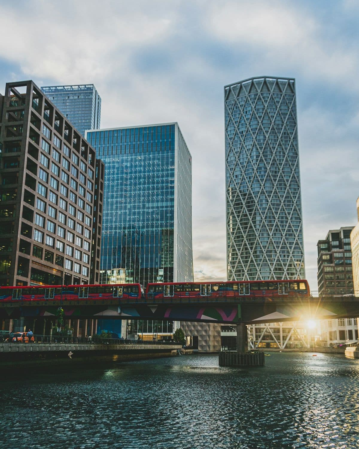 Office towers at Canary Wharf in London, with a train crossing a bridge over the dock