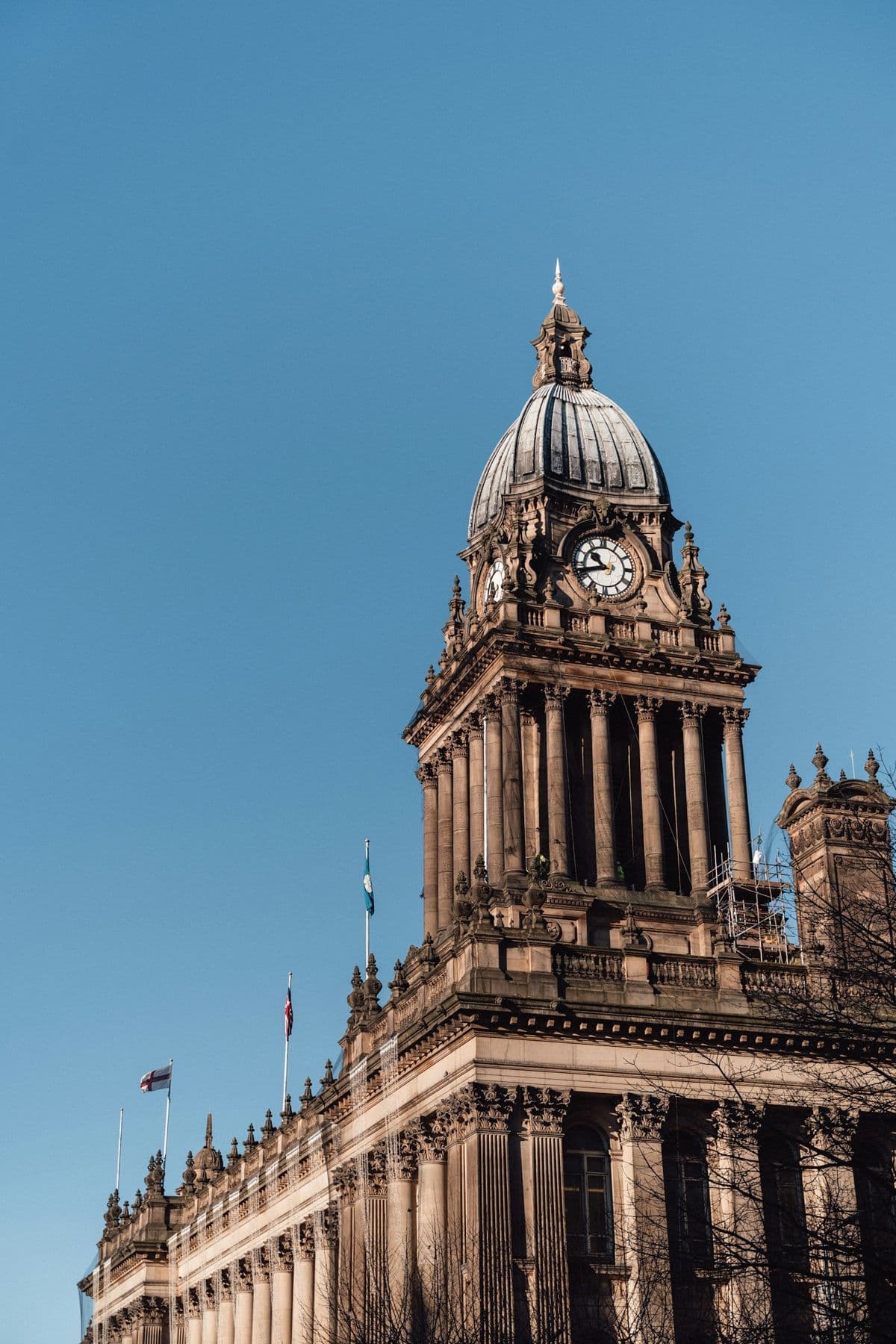 A Victorian town hall with a domed clock tower against a clear blue sky