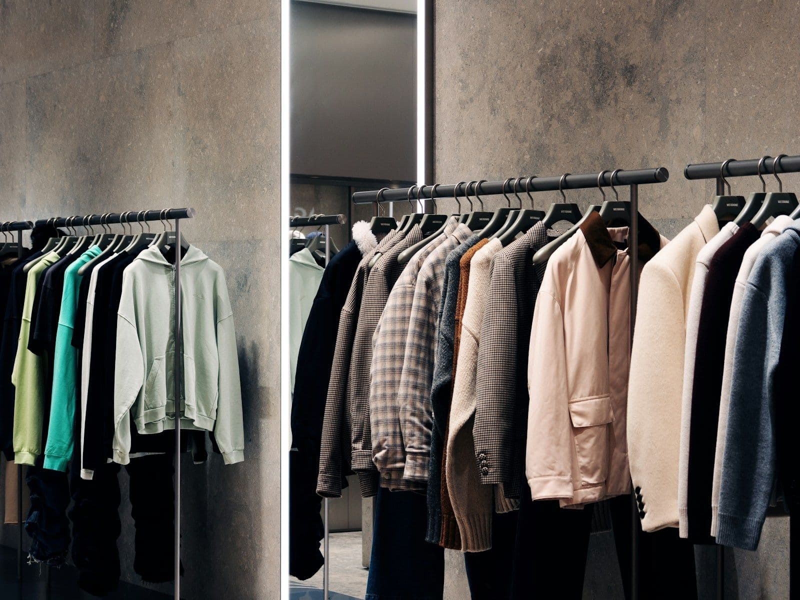 Jackets and knitwear hanging on rails in a clothing store