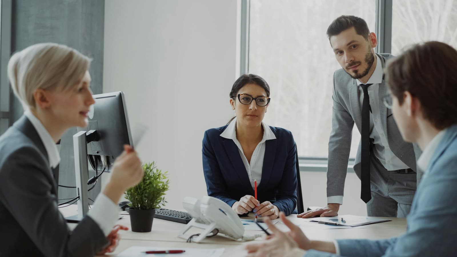 Business professionals discussing plans around a meeting table