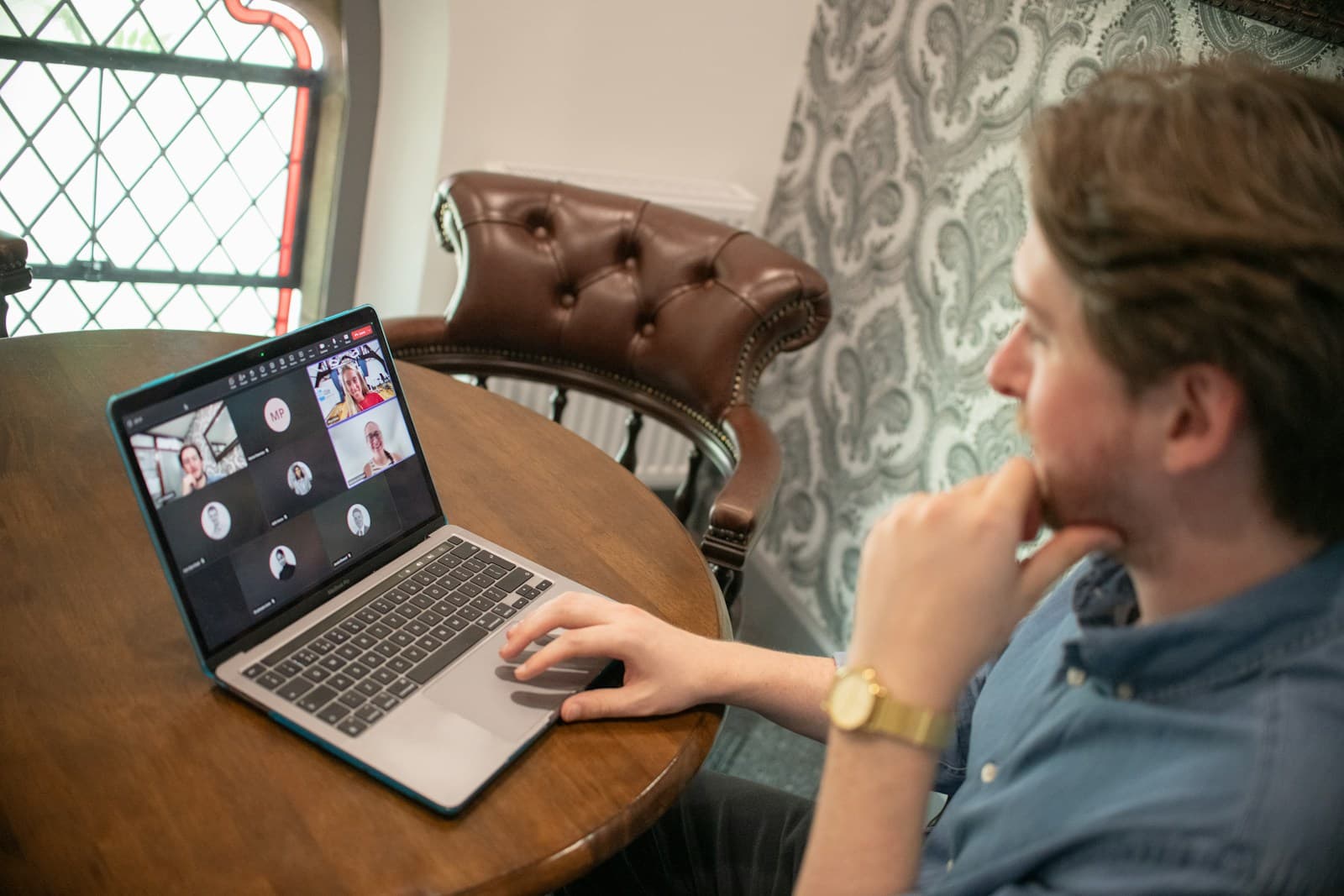 A man taking part in a video conference call on his laptop