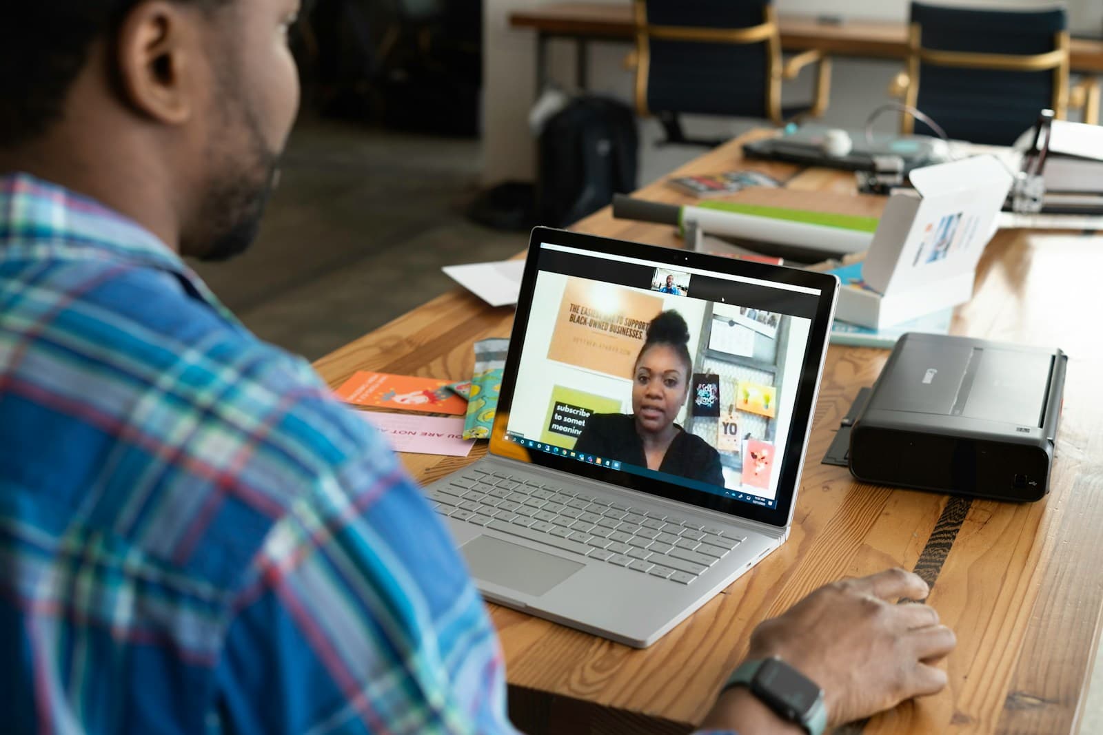 A man on a video call with a colleague on his laptop
